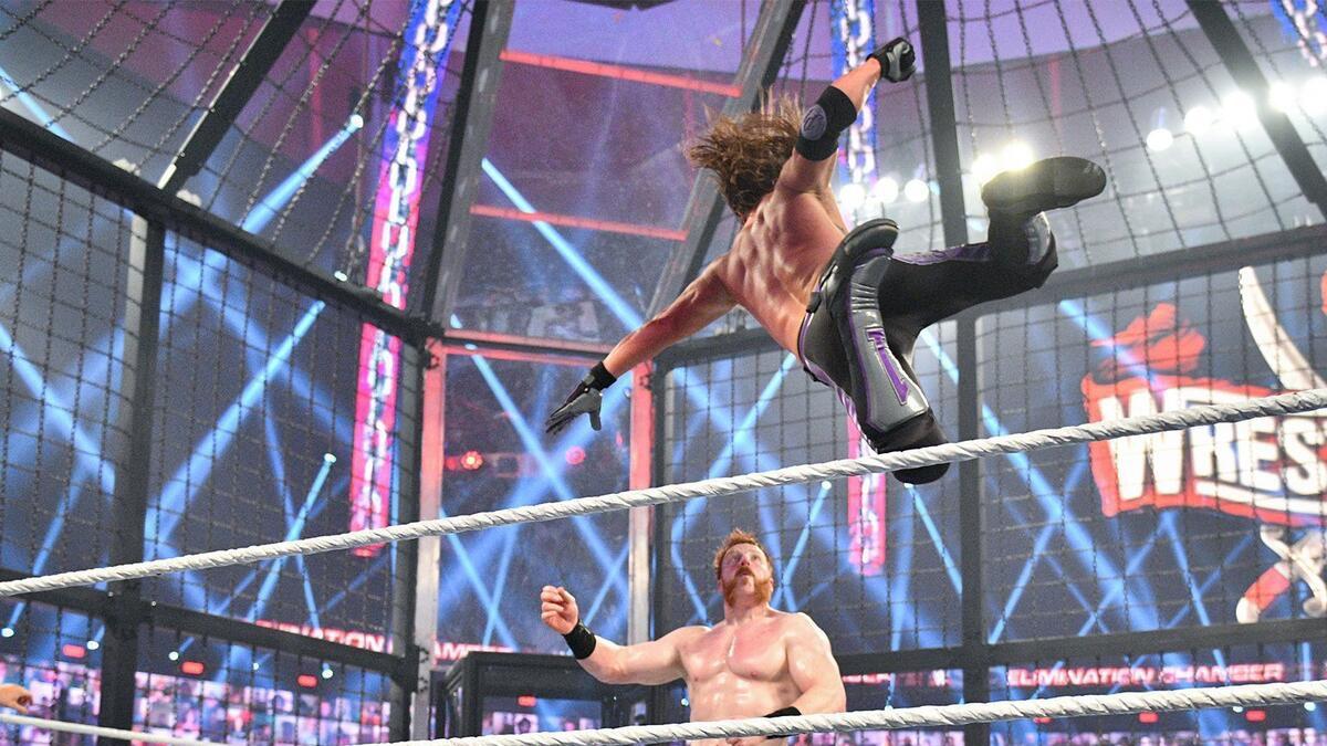 Sheamus looking on as AJ Styles is mid-air for a Phenomenal Forearm
