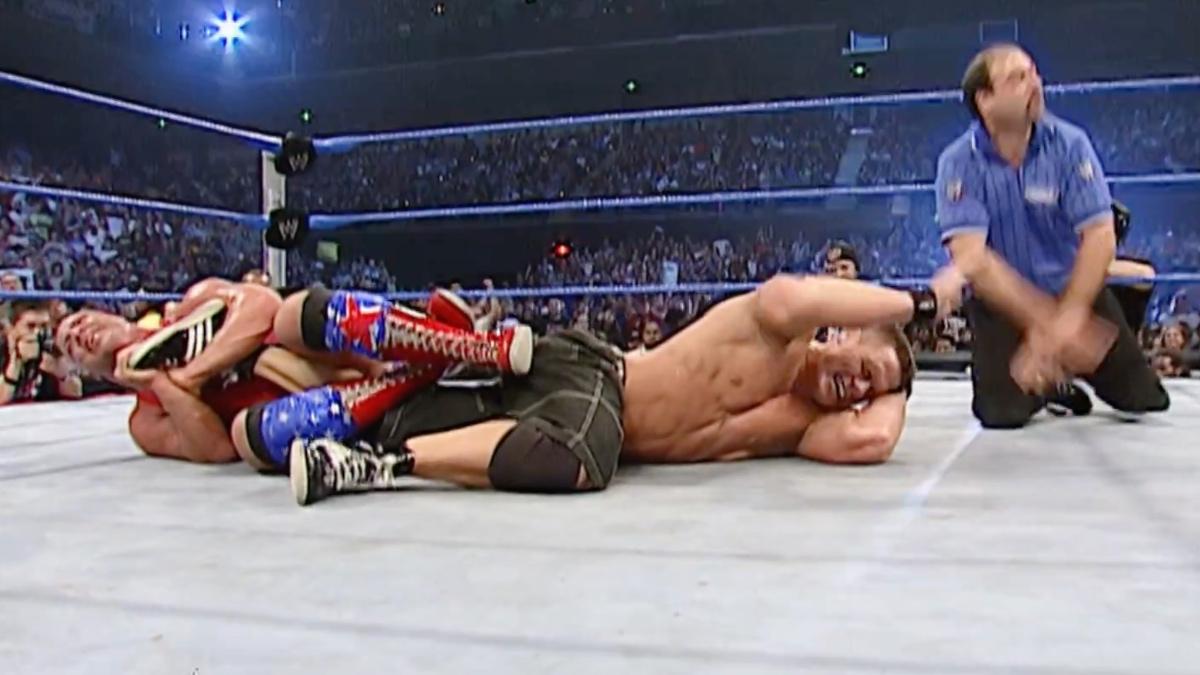 Kurt Angle with John Cena trapped in an Ankle Lock as Cena taps out