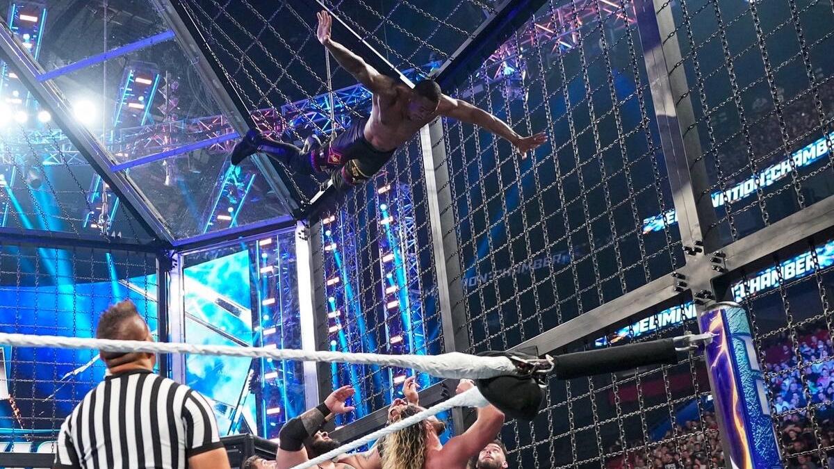Montez Ford in mid air as the rest of the wrestlers wait to catch him at WWE Elimination Chamber 2023