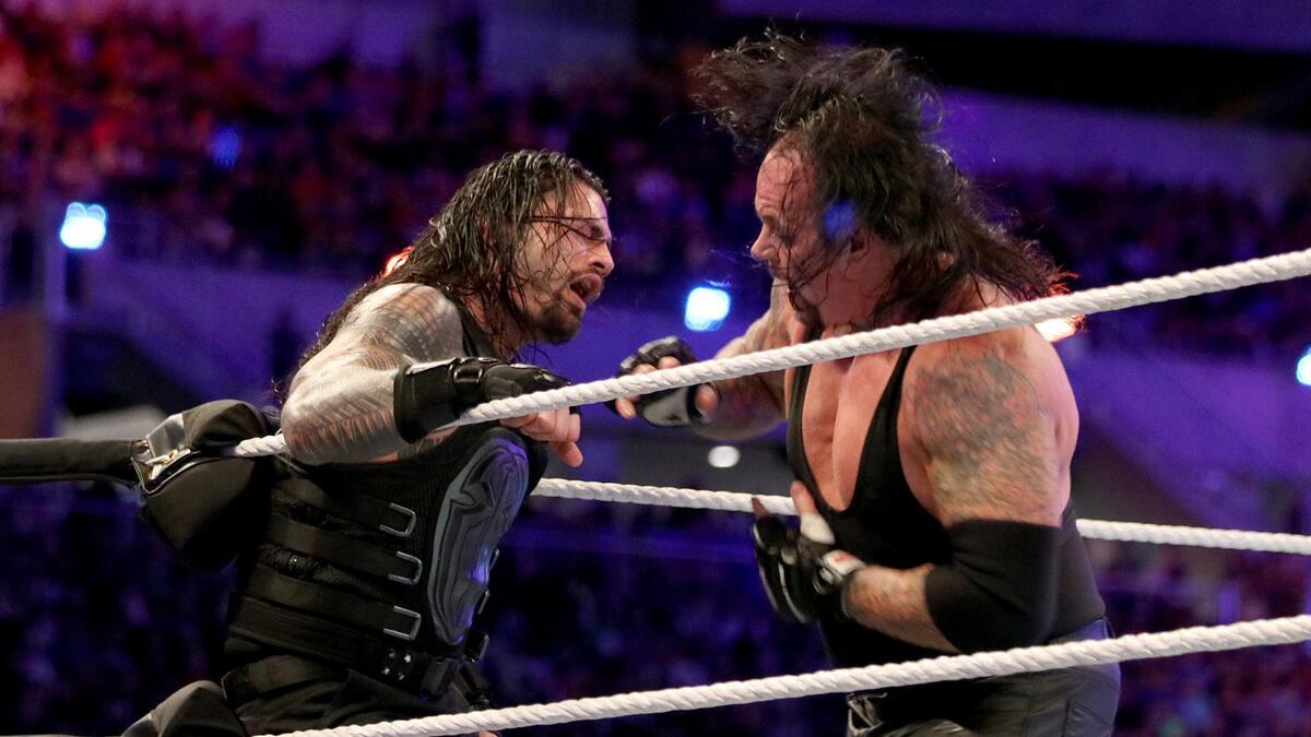 The Undertaker punching Roman Reigns in the corner at WWE WrestleMania 33